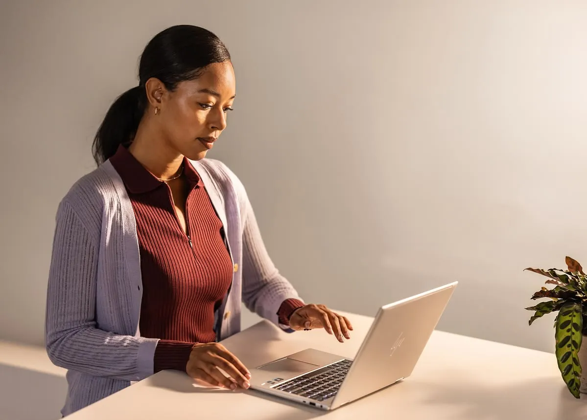 A professional working on a laptop at her desk