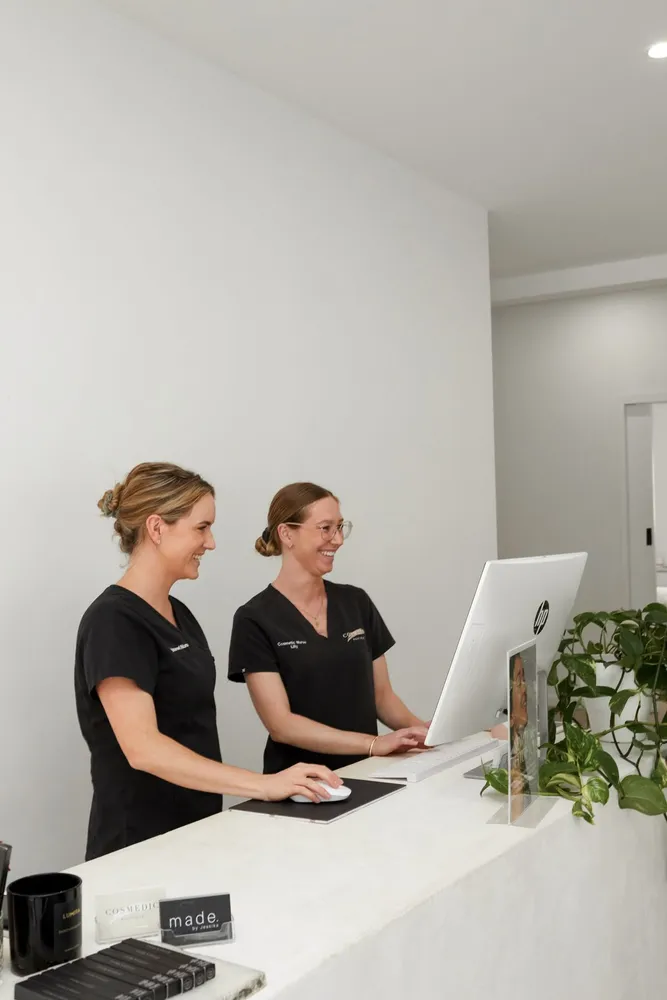 Two people at a clinic reception desk